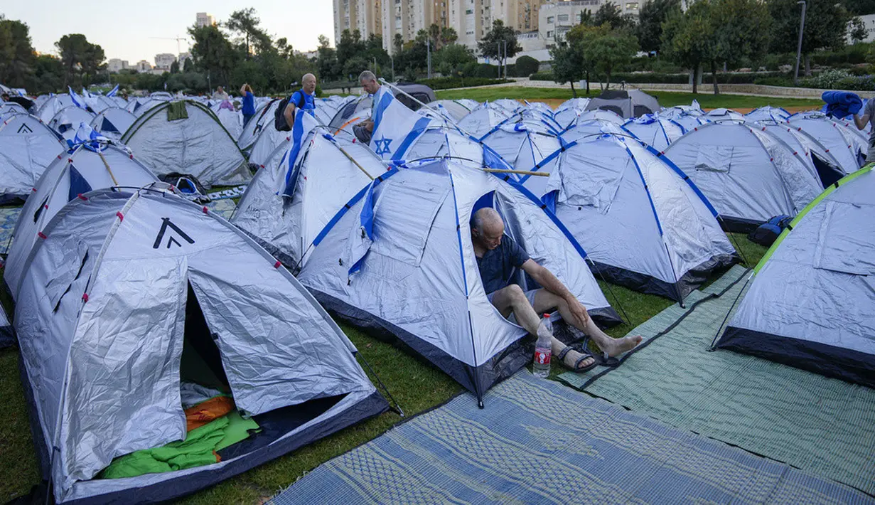 <p>Tenda dengan bendera Israel di atasnya terlihat berjejer di dekat parlemen Israel, Knesset. (AP Photo/Ohad Zwigenberg)</p>
