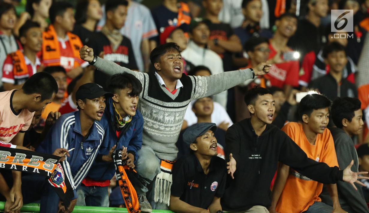 Suporter Persija membentangkan tangan merayakan kemenangan tim Macan Kemayoran atas Perserui pada lanjutan Liga 1 Indonesia di Stadion Patriot Candrabhaga, Bekasi, Selasa (13/6). Persija menang telak 3-0 atas perserui. (Liputan6.com/Helmi Fithriansyah)