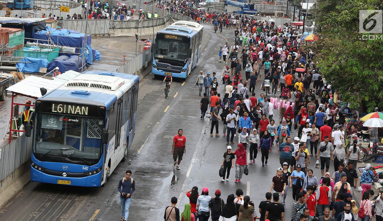 Bus Transjakarta melintasi Jalan Jendral Sudirman dan MH Thamrin ketika pelaksanaan car free day (CFD) di Jakarta, Minggu (11/2). Warga berolahraga atau sekadar berjalan-jalan di hari bebas kendaraan tersebut. (Liputan6.com/Immanuel Antonius)