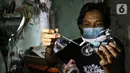 Pengrajin Wawang Kurniawan, mengecat miniatur motor RX-King di Kampung Dukuh, Serua, Tangerang Selatan, Sabtu (17/10/2020). Miniatur motor yang terbuat dari barang bekas paralon, kaleng minuman mulai digeluti sejak tahun 2018. (Liputan6.com/Fery Pradolo)