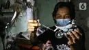 Pengrajin Wawang Kurniawan, mengecat miniatur motor RX-King di Kampung Dukuh, Serua, Tangerang Selatan, Sabtu (17/10/2020). Miniatur motor yang terbuat dari barang bekas paralon, kaleng minuman mulai digeluti sejak tahun 2018. (Liputan6.com/Fery Pradolo)