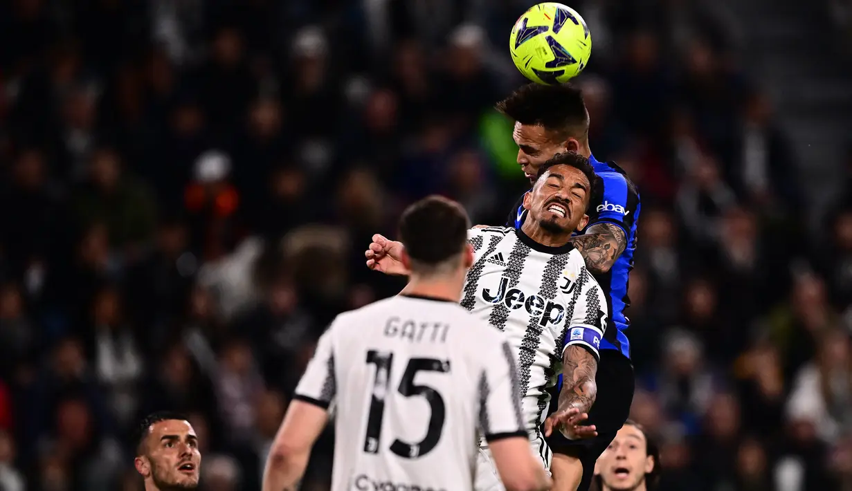 Striker Inter Milan, Lautaro Martinez (belakang) berduel udara dengan bek Juventus, Danilo pada laga leg pertama semifinal Coppa Italia 2022/2023 di Allianz Stadium, Turin, Rabu (5/4/2023) dini hari WIB. (AFP/Marco Bertorello)