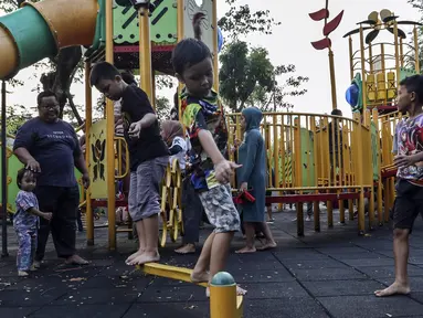 Anak-anak didampingi orangtua bermain di RPTRA Bhineka Jakarta Selatan, Sabtu (30/7/2022). Selain menjadi alternatif mengisi libur bersama keluraga, taman juga menjadi ruang bagi warga untuk berinteraksi sosial sekaligus mengeduksi anak untuk bermain bersama teman-teman dengan wahana yang tersedia. (Liputan6.com/Johan Tallo)
