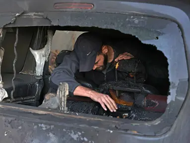 Seorang pria Palestina memeriksa mobil yang rusak akibat serangan oleh pemukim Israel di desa Jabaa dekat Bethlehem, di Tepi Barat yang diduduki, pada Selasa 18 November 2025. Kekerasan yang dilakukan pemukim Israel meningkat tajam dalam beberapa pekan terakhir di seluruh Tepi Barat. (AHMAD GHARABLI/AFP)