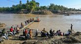 Sejumlah warga menunggu waktu naik rakit tali untuk menyeberangi Sungai Peusangan menyusul banjir bandang yang menghancurkan desa-desa di sekitarnya di Kabupaten Bireuen, provinsi Aceh, pada Senin 5 Januari 2026. Sebulan lebih pasca terjangan banjir bandang, warga di sekitar Sungai Peusangan Bireuen Aceh masih menggunakan metode penyeberangan darurat. (CHAIDEER MAHYUDDIN/AFP)