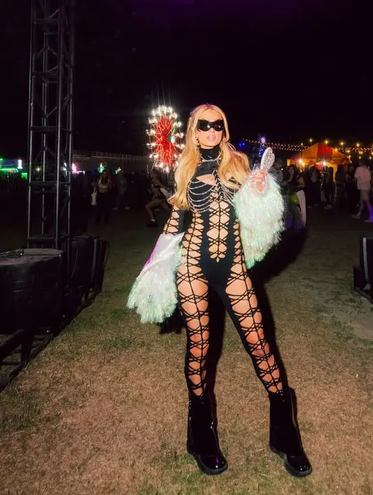 <p>Paris Hilton tampil maksimal mengenakan pakaian berjaring warna hitam selaras dengan sepatu boots dan kacamata hitamnya. Ia memadukannya dengan jaket fur putih. [@parishilton]</p>