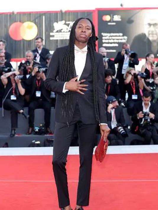 Jeremy O. Harris mengenakan tuxedo Hucci dengan kemeja dan dasi kupu-kupu warna champagne. Serta membawa tas suede burgundy Gucci Blondie. 
(Foto: Gucci)