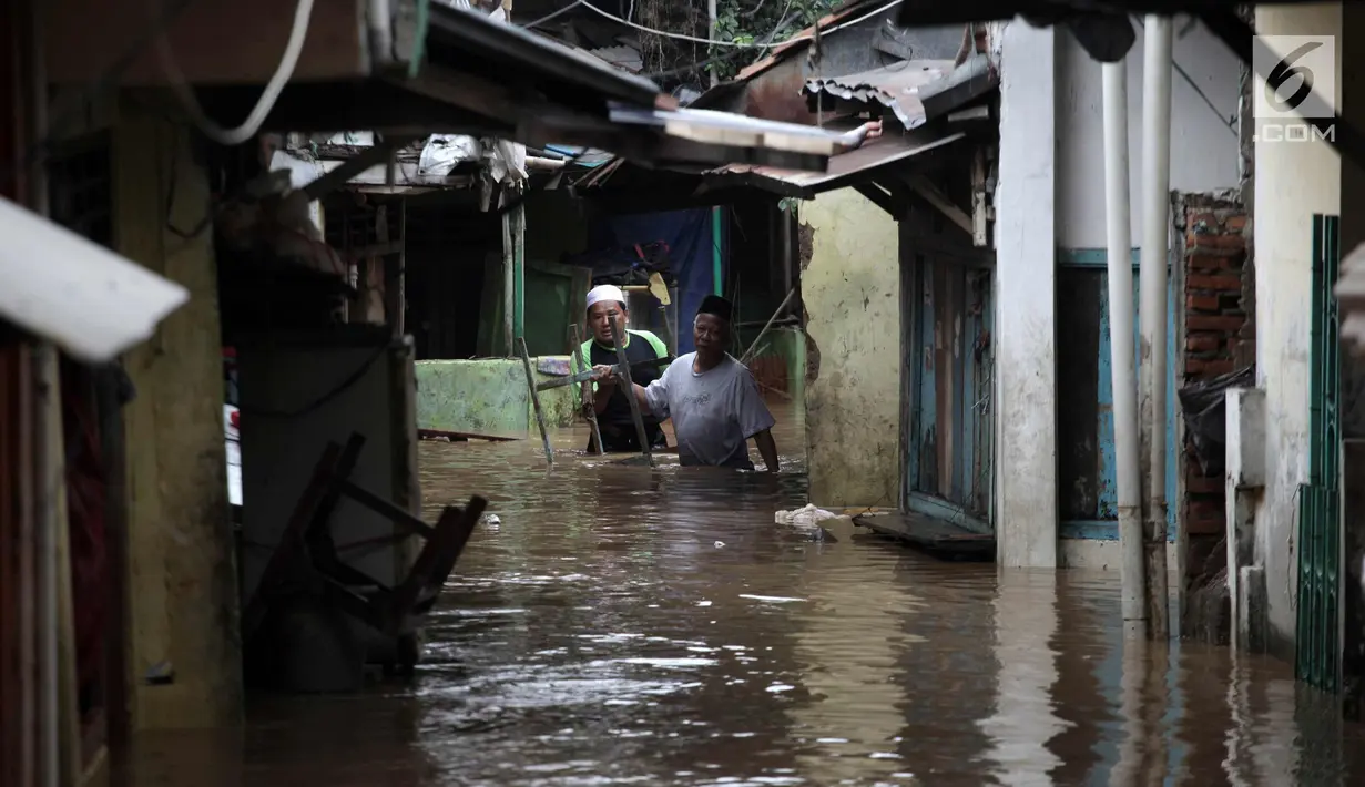 Warga melintasi banjir di Jalan Kebon Pala, Kampung Melayu, Jatinegara, Jakarta Timur, Rabu (7/2). Setelah sempat surut, banjir kembali merendam permukiman warga dengan ketinggian air mencapai sekitar 170 cm. (Liputan6.com/Arya Manggala)