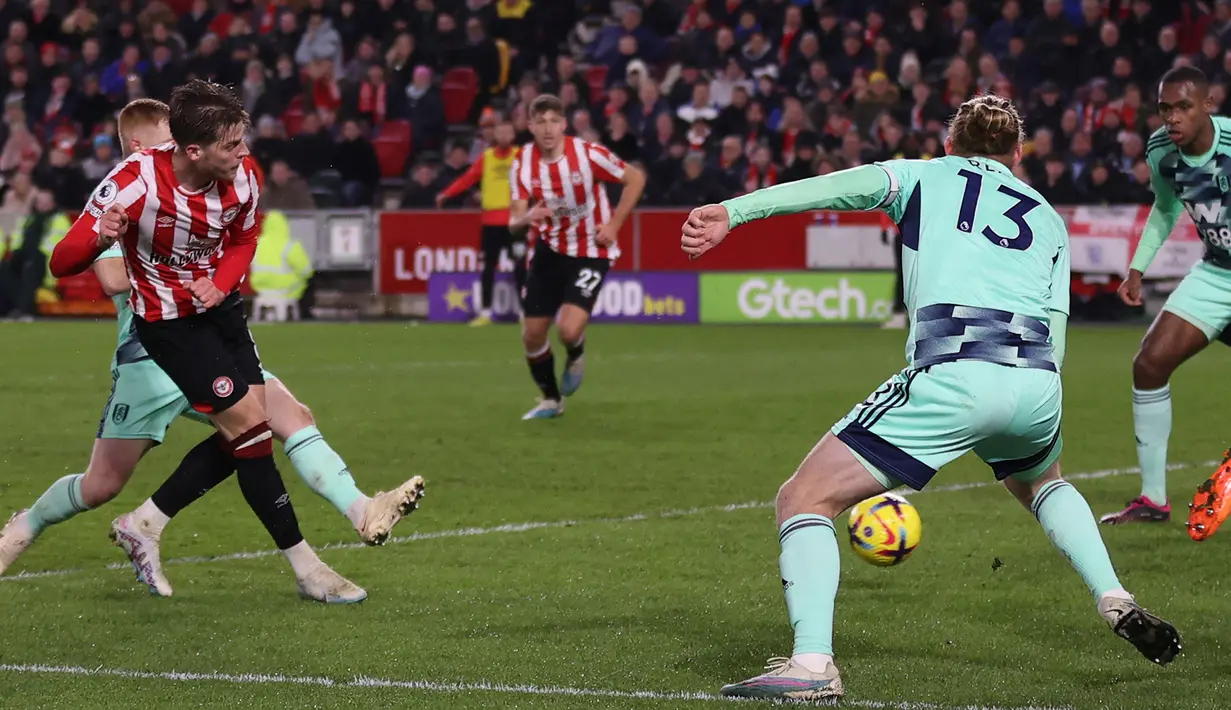 Gelandang Brentford, Mathias Jensen (kiri) melepaskan tendangan yang berbuah gol ke gawang Fulham pada laga Liga Inggris 2022/2023 di Gtech Community Stadium, London (6/3/2023). Mathias Jensen didatangkan dari Celta Vigo pada awal musim 2019/2020 dengan nilai transfer 3,8 juta euro saat Brentford masih berkompetisi di Championship. Masuk dalam skuad inti musim ini, ia selalu bermain dalam seluruh 24 laga Brentford di Liga Inggris dengan torehan 4 gol dan 4 assist. (AFP/Adrian Dennis)