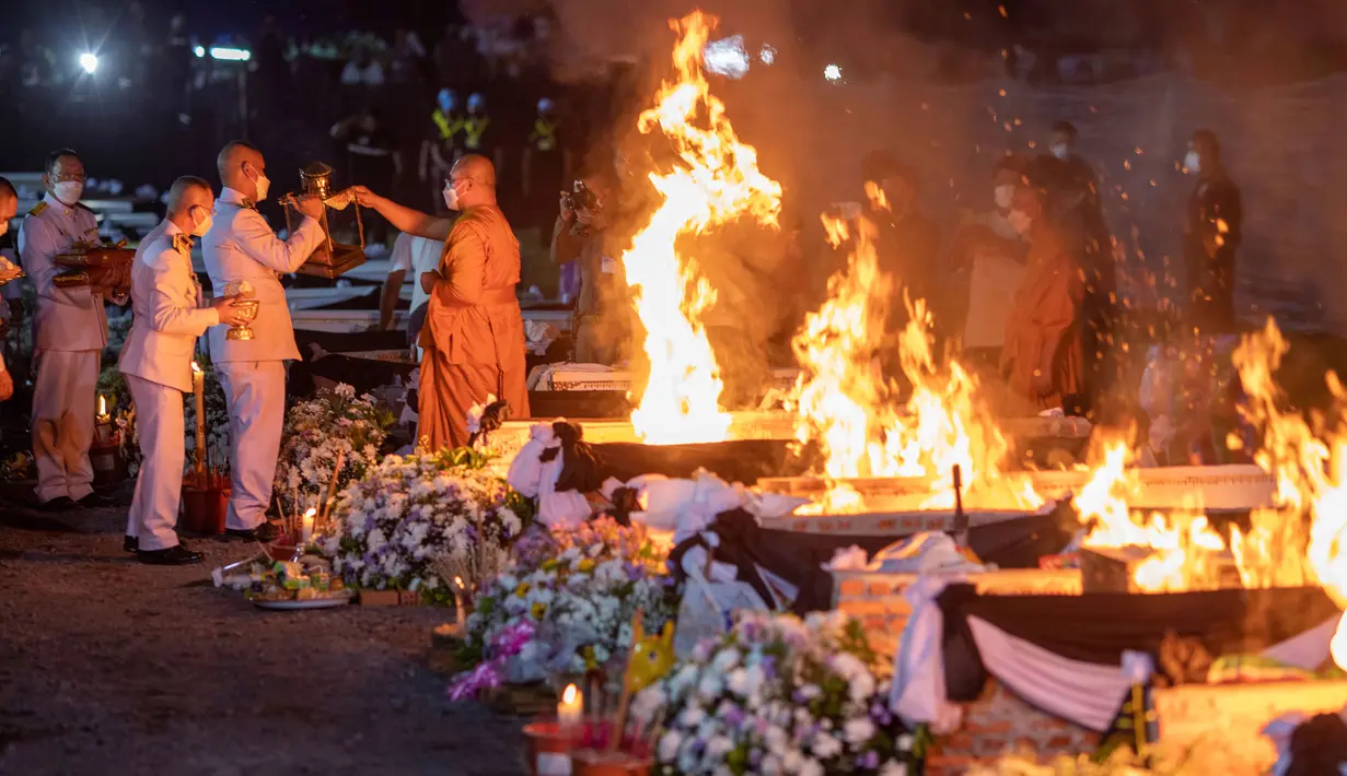 Seorang biksu menyalakan api untuk mengkremasi korban tewas dalam serangan pusat penitipan anak di Kuil Wat Rat Samakee, Uthai Sawan, Thailand, Selasa (11/10/2022). Ini adalah pembunuhan massal terbesar oleh seorang individu dalam sejarah Thailand. (AP Photo/Wason Wanichakorn)