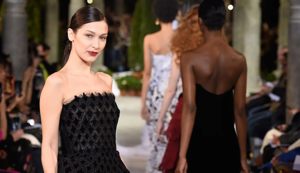 Model Bella Hadid berpose di atas catwalk mengenakan koleksi terbaru dari Oscar de la Renta dalam New York Fashion Week, AS (12/2). Bella Hadid tampil cantik dengan gaun hitam panjang tanpa lengan. (AFP Photo/Slaven Vlasic)