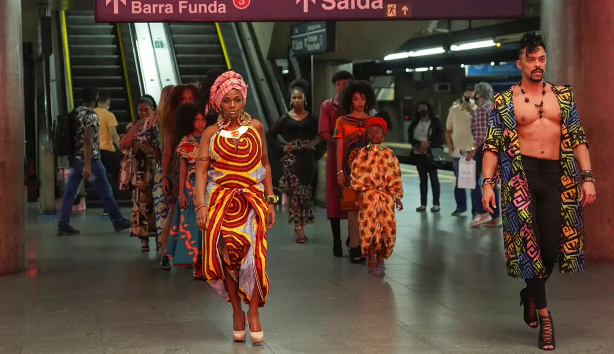 Model mengenakan pakaian yang dirancang oleh siswa dari komunitas Afro-Brasil jelang Hari Kesadaran Kulit Hitam dalam stasiun kereta bawah tanah di Sao Paulo, Brasil, 19 November 2021. November diakui sebagai Bulan Kesadaran Kulit Hitam. (AP Photo/Andre Penner)