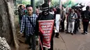 Aksi jalan kaki sambil menutup mata di depan Istana Negara, Jakarta, Selasa (18/11/2014). (Liputan6.com/Faizal Fanani)