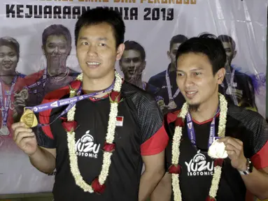 Pasangan ganda putra Indonesia, Mohammad Ahsan/Hendra Setiawan, menunjukan mendali saat konfrensi pers di Bandara Soekarno-Hatta, Tangerang, Selasa (27/8). Ahsan/Hendra meraih gelar pada Kejuaraan Dunia Bulutangkis 2019. (Bola.com/Yoppy Renato)