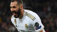 Pemain depan Real Madrid Karim Benzema berselebrasi usai mencetak gol ke gawang PSG pada pertandingan Grup A Liga Champions di stadion Santiago Bernabeu, Spanyol (26/11/2019). Di pertandingan ini Benzema mencetak dua gol. (AFP Photo/Gabriel Bouys)