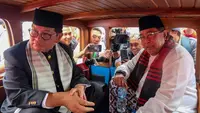 Bakal calon gubernur dan wakil gubernur dari Partai Demokrasi Indonesia Perjuangan (PDIP), Pramono Anung dan Rano Karno saat berada dalam oplet menuju kantor Komisi Pemilihan Umum (KPU) Provinsi DKI Jakarta, Rabu (28/8/2024). (merdeka.com/Arie Basuki)