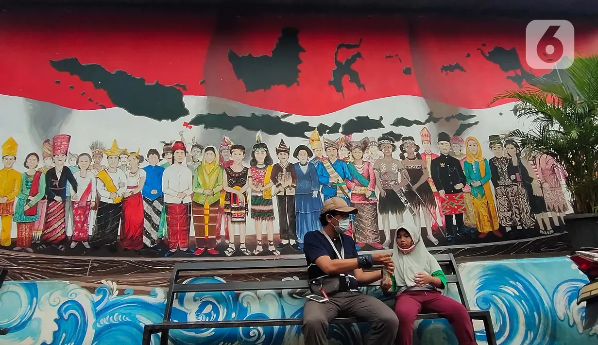 Warga duduk dengan latar belakang mural berbagai pakaian adat Indonesia di Kampung Pancasila, Karang Tengah, Kota Tangerang, Selasa (1/6/2021). Sejumlah kegiatan diadakan warga, Komunitas Taman Potret dan TNI ini untuk memperingati Hari kelahiran Pancasila. (Liputan6.com/Angga Yuniar)