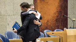 Menteri Luar Negeri Belanda Halbe Zijlstra memeluk perdana menteri Mark Rutte setelah mengumumkan pengunduran dirinya di Den Haag (13/2). (Martijn Beekman/ANP/AFP)