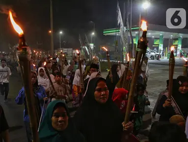 Warga melakukan kegiatan pawai obor di jalan raya Joglo, Jakarta Barat, Rabu (26/2/2025) malam. (Liputan6.com/Angga Yuniar)