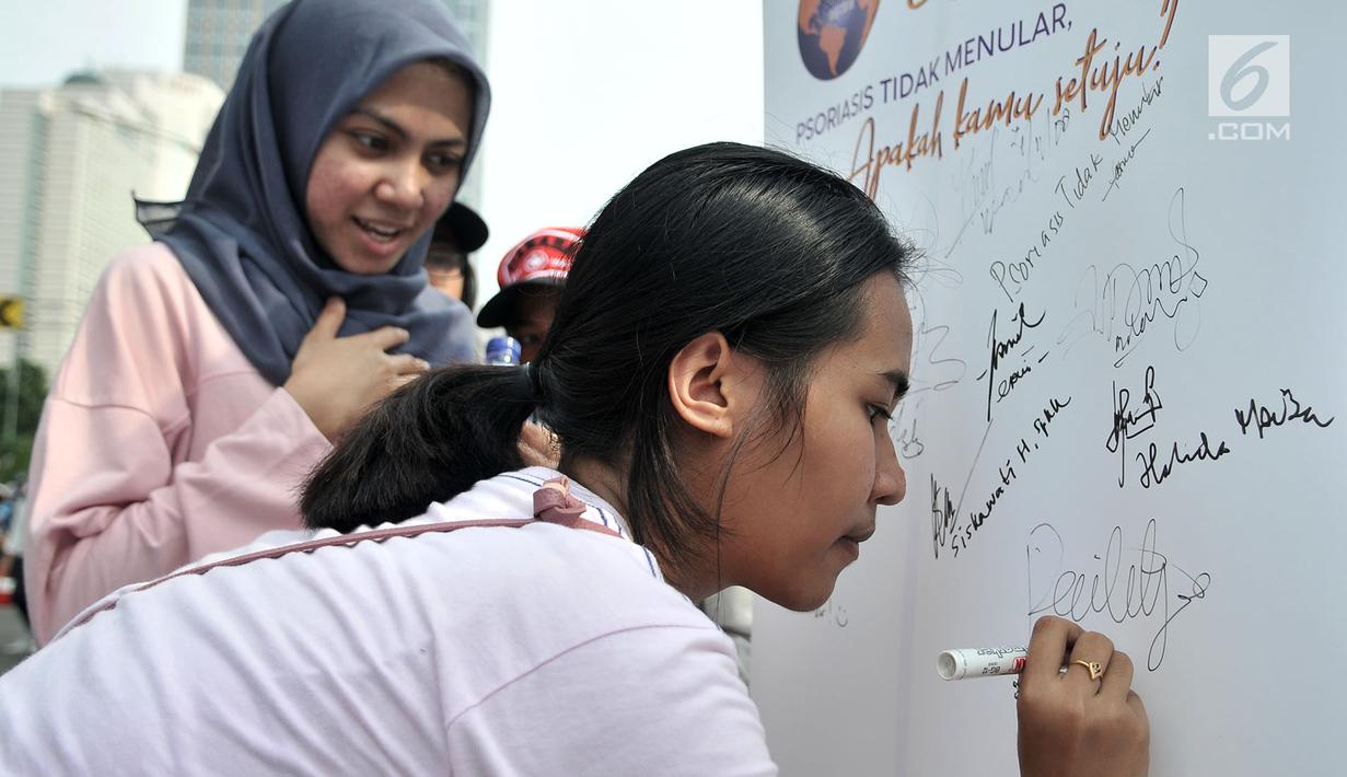 Seorang warga membubuhkan tanda tangan dukungan saat kampanye tentang penyakit Psoriasis di kawasan car free day, Jakarta, Minggu (4/11). Kampanye itu digelar mahasiswa dari Fakultas Kedokteran UI bekerjasama dengan RSCM. (Merdeka.com/Iqbal S. Nugroho)