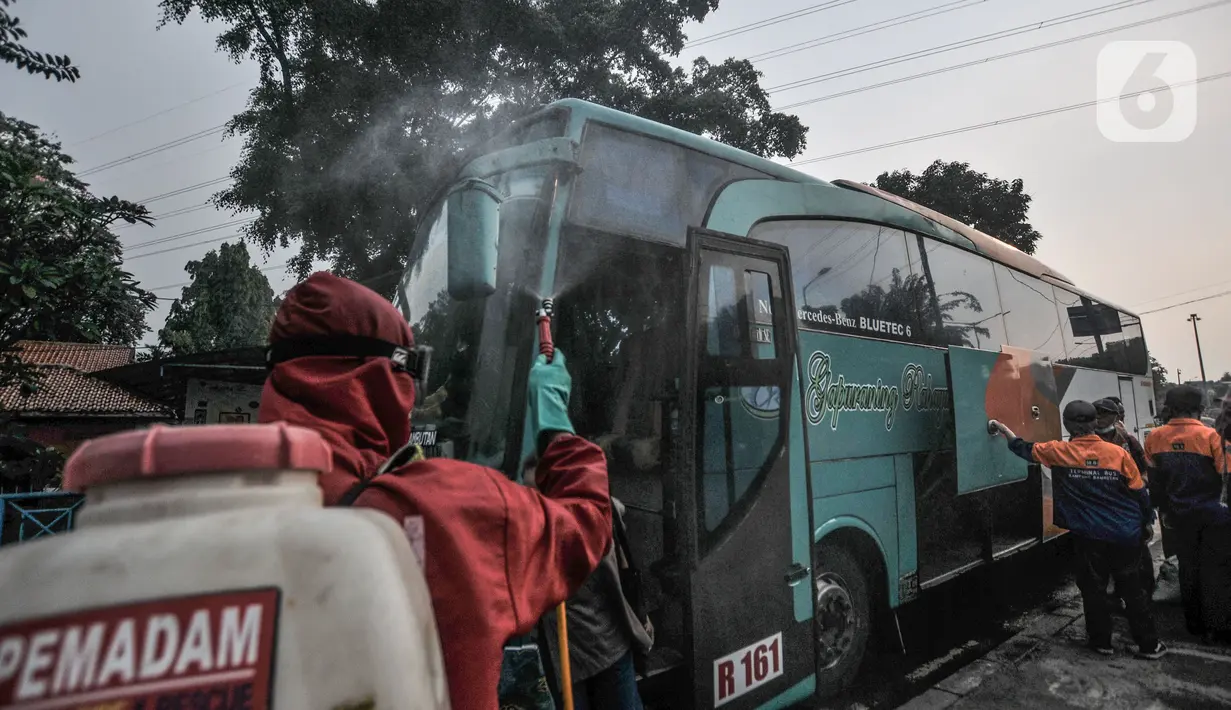Petugas pemadam kebakaran menyemprotkan disinfektan kepada penumpang bus AKAP di Terminal Kampung Rambutan, Jakarta, Minggu (23/5/2021). Penyemprotan rutin dilakukan kepada bus AKAP dan penumpang selama arus mudik Lebaran sebagai langkah mencegah penyebaran Covid-19. (merdeka.com/Iqbal S Nugroho)