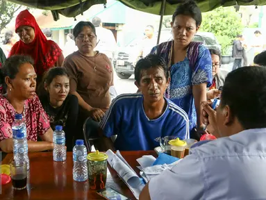 Petugas Kelurahan Penjaringan memberikan penjelasan kepada warga penguni pasar ikan yang akan dibongkar, Jakarta, Rabu (30/3). Sebanyak 310 rumah yang berada di pasar ikan akan dibongkar pemprov DKI Jakarta. (Liputan6.com/Yoppy Renato)