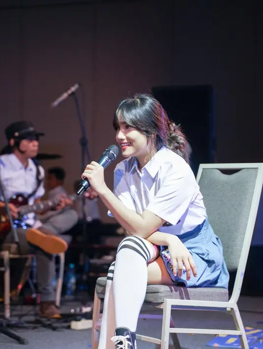 Penampilan Fuji semakin menggemaskan dengan pleated mini skirt biru, kaus kaki putih panjang ala Harajuku style, dan sepatu Converse dengan heels. [Foto: Instagram/fuji_an]