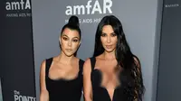 Kim Kardashian (kanan) dan Kourtney Kardashian berpose saat menghadiri Gala amfAR New York AIDS 2019 di Cipriani Wall Street, Rabu (6/2). (Photo by Evan Agostini/Invision/AP)