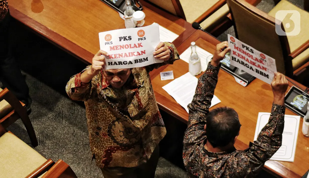 Anggota Fraksi PKS memegang poster bertuliskan “Tolak Kenaikan Harga BBM” saat Rapat Paripurna ke-4 masa persidangan I tahun 2022-2023 di Kompleks Parlemen, Senayan, Jakarta, Selasa (6/9/2022). Dalam rapat paripurna ini beragendakan pengambilan keputusan RUU tentang pertanggungjawaban APBN TA 2021. (Liputan6.com/Angga Yuniar)
