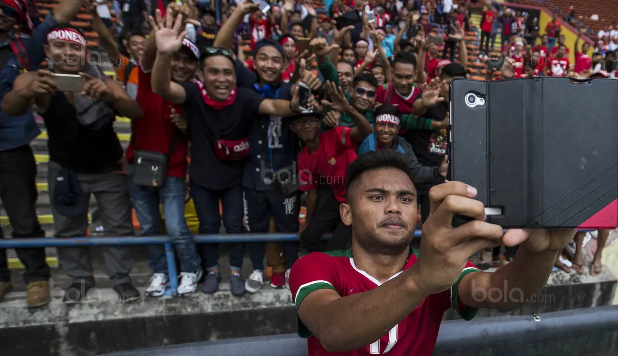 4. Gelandang Timnas Indonesia, Saddil Ramdani, melakukan swafoto dengan suporter usai laga melawan Thailand. (Bola.com/Vitalis Yogi Trisna)