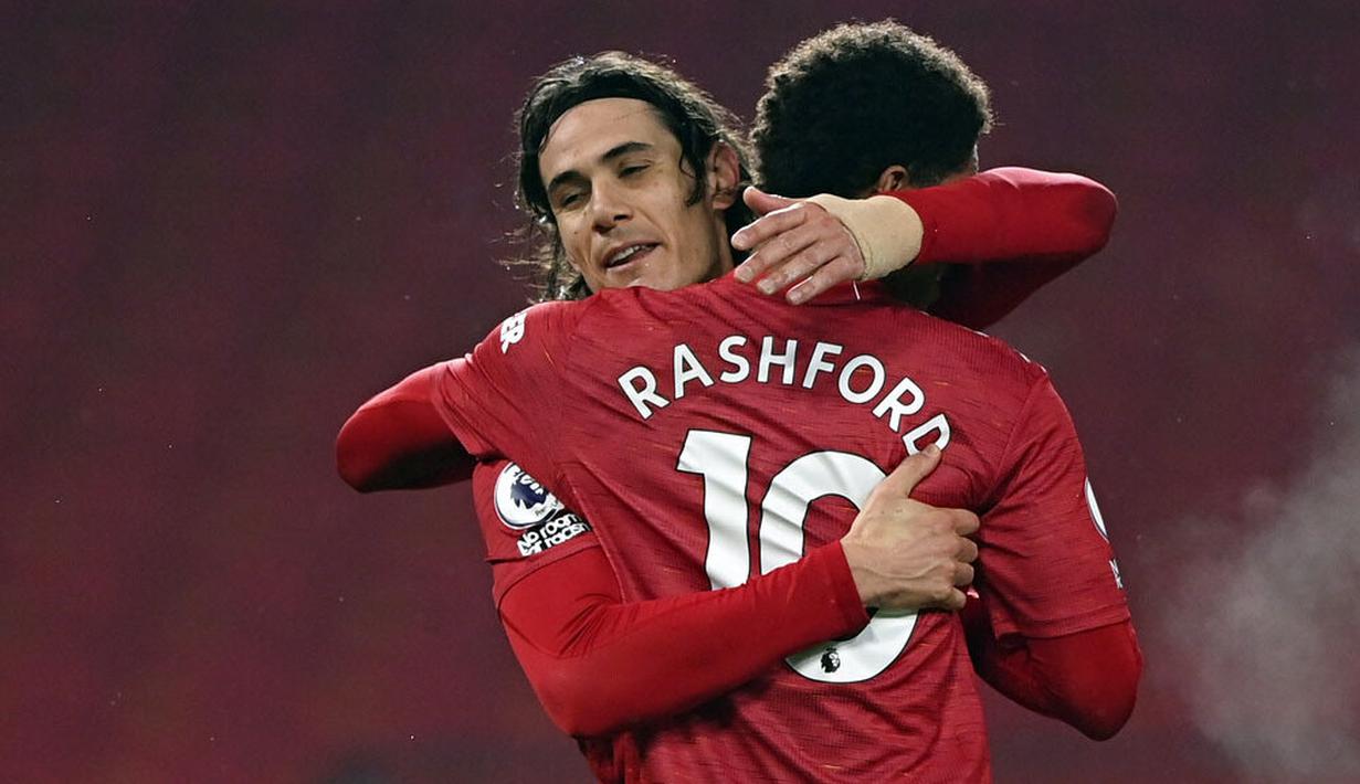Striker Manchester United, Edinson Cavani, melakukan selebrasi bersama Marcus Rashford usai mencetak gol ke gawang Southampton pada laga Liga Inggris di Stadion Old Trafford, Selasa (2/2/2021). Setan Merah menang dengan skor 9-0. (Laurence Griffiths/Pool via AP)