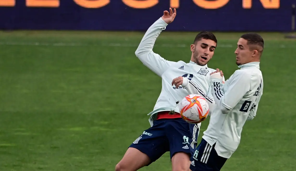 Gelandang Spanyol Ferran Torres (kiri) dan penyerang Spanyol Rodrigo mengambil bagian dalam sesi latihan di La Coruna, Senin (28/3/2022).  Spanyol akan beruji coba melawan Islandia pada pertandingan International Friendly di Stadion Riazor, Rabu 30 Maret 2022 dini hari WIB. (JAVIER SORIANO/AFP)