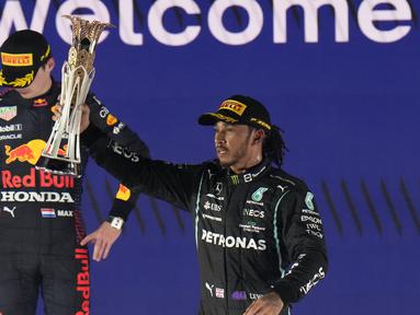Pembalap Mercedes Lewis Hamilton merayakan kemenangannya pada F1 GP Arab Saudi di depan pembalap Red Bull Max Verstappen, Jeddah, Minggu, 5 Desember 2021. Kemenangan Lewis Hamilton membuatnya kini menyamai poin Max Verstappen di klasemen F1, yakni 369,5 poin. (AP Photo/Hassan Ammar)