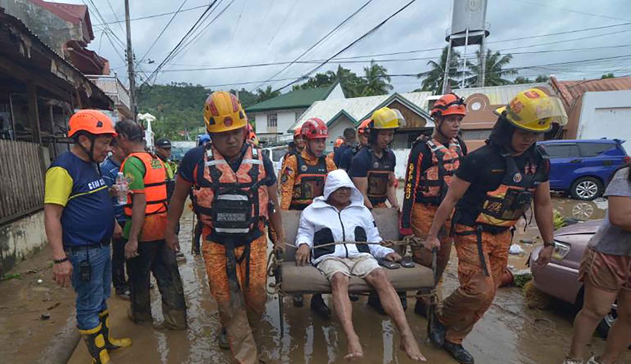 Tim penyelamat mengevakuasi seorang warga dari rumahnya yang terendam banjir menyusul hujan deras yang dibawa oleh Topan Kalmaegi di sebuah permukiman di Kota Cebu, Filipina tengah, pada Selasa 4 November 2025. Topan Kalmaegi menerjang wilayah permukiman warga di Kota Cebu, Filipina tengah pada Selasa 4 November 2025. (Alan TANGCAWAN/AFP)