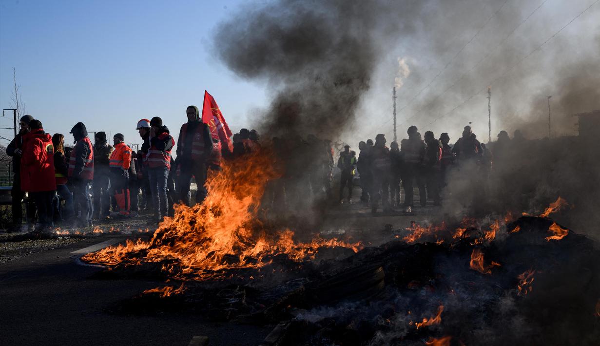 Kepulan asap hitam mewarnai aksi yang dijalankan puluhan anggota serikat pekerja Konfederasi Umum Buruh Prancis (CGT) untuk menentang perombakan dana pensiun yang sangat tidak populer di Donges, Prancis Barat, Rabu (8/2/2023). Prancis bersiap menghadapi pemogokan baru dan demonstrasi massal menentang proposal Presiden Prancis untuk mereformasi pensiun Prancis, termasuk menaikkan usia pensiun dari 62 menjadi 64 tahun. (LOIC VENANCE/AFP)