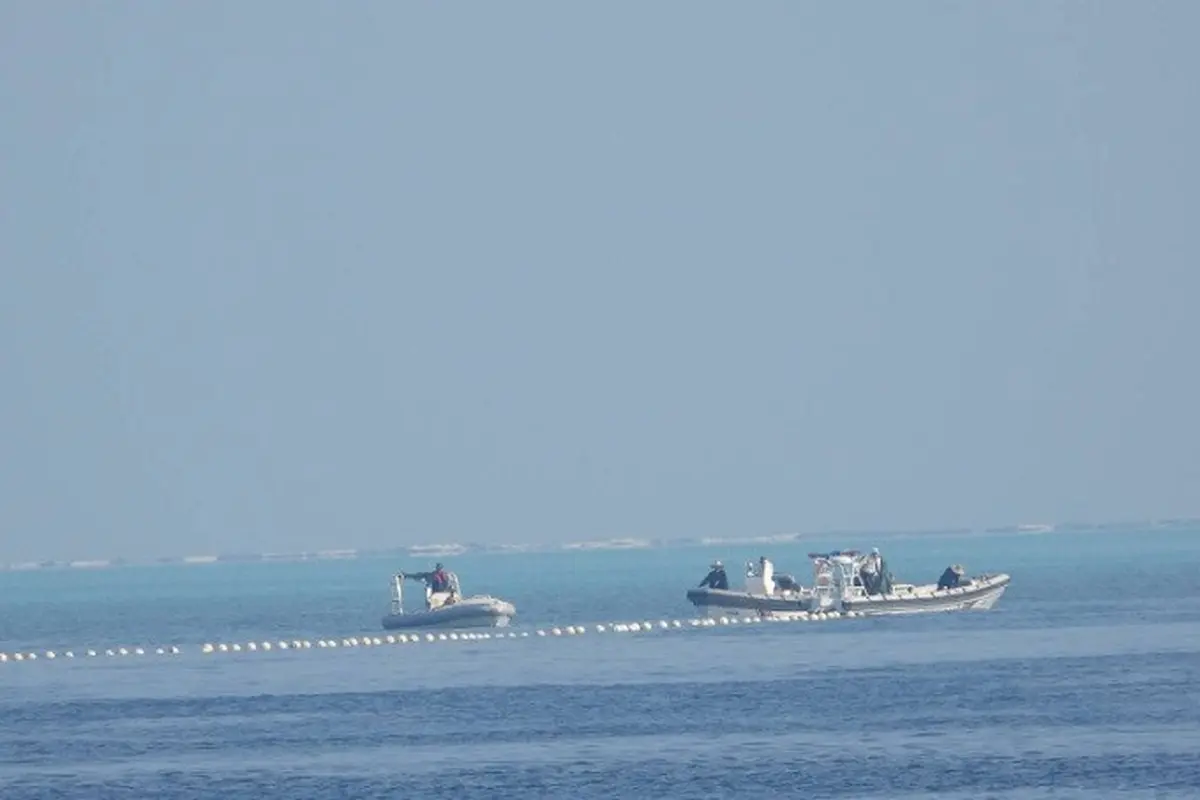 Gambar menunjukkan penghalang terapung dijaga oleh kapal China di wilayah yang dikenal di Filipina sebagai Bajo de Masinloc di Laut China Selatan. (Dok. Philippine Coast Guard)