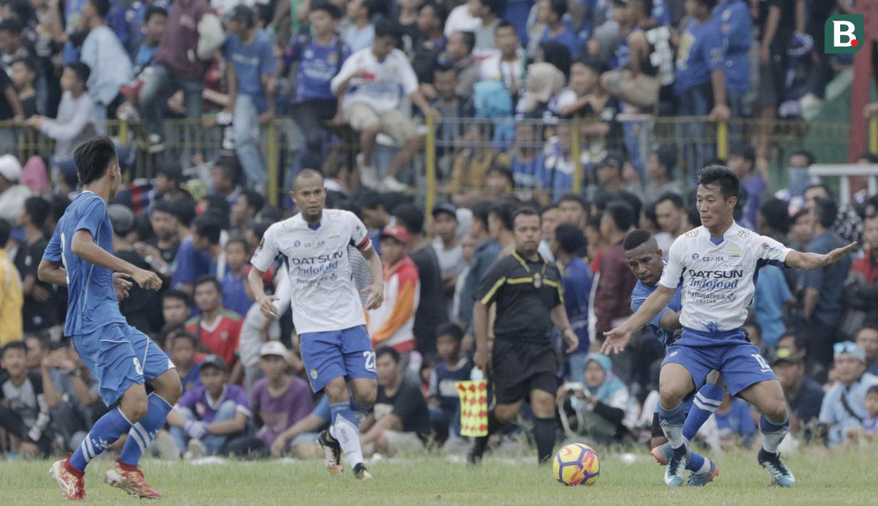 Striker Perserang Serang, Oktovianus Maniani, berebut bola dengan bek Persib Bandung, Henhen Herdiana, pada laga persahabatan di Stadion Maulana Yusuf, Serang, Kamis (1/3/2018). Persib menang 6-0 atas Perserang. (Bola.com/M Iqbal Ichsan)