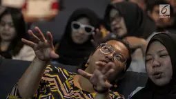 Relawan bisik menjelaskan alur cerita kepada tunanetra saat menyaksikan Bioskop Bisik di Pavilliun 28, Jakarta, Minggu (14/1). Hal ini membuat penyandang tunanetra dapat mengerti dan merasakan emosi yang ada di film tersebut. (Liputan6.com/Faizal Fanani)