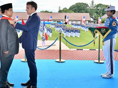 Foto selebaran yang diambil dan dirilis pada 29 Mei 2025 oleh Istana Kepresidenan ini menunjukkan Presiden Prancis Emmanuel Macron (kanan depan) menganugerahkan penghargaan Grand Croix de la LÈgion díHonneur kepada Presiden Indonesia Prabowo Subianto dalam kunjungannya di Akademi Militer, Magelang, Jawa Tengah, Kamis 29 Mei 2025. (Handout/Istana Kepresidenan Indonesia/AFP)