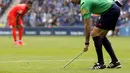 Wasit Antonio Mateu mengambil tongkat yang dilemparkan ke dalam stadion (REUTERS/Gustau Nacarino).