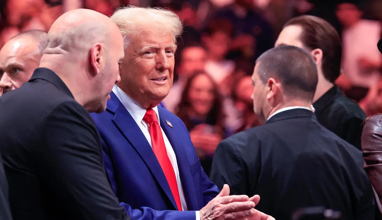 Donald Trump memasuki arena sesaat sebelum dimulainya babak utama dengan didampingi oleh kepala eksekutif UFC, Dana White, pendukung utamanya selama kampanye pemilihan presiden 2024. (Kena Betancur/AFP)