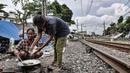 Tunawisma beraktivitas di dekat gubuknya yang berada di bantaran rel kereta api kawasan Senen, Jakarta, Minggu (14/2/2021). Mayoritas penghuni bantaran rel di kawasan ini adalah pemulung dengan rata-rata berpenghasilan Rp30ribu per hari. (merdeka.com/Iqbal S. Nugroho)