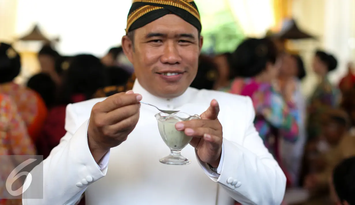 Seorang tamu memperlihatkan dawet usai prosesi sade dawet (jual dawet) di depan rumah kontrakan mempelai wanita di Jalan Kutai Raya, Banjarsari, Solo, Jateng, Rabu (10/6/2015). (Liputan6.com/Faizal Fanani)