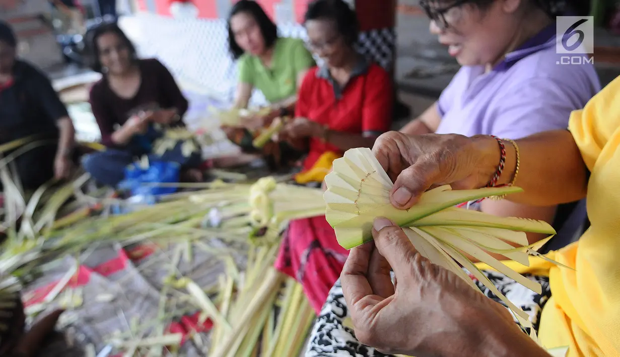 Sejumlah ibu serati banten mempersiapkan Gebogan yang akan digunakan dalam upacara Mecaru dalam menyambut perayaan hari Raya Nyepi dan Tahun baru Saka 1941 di Pura Tribhuana Agung Sukmajaya Depok, Jawa Barat, Selasa (5/3). (Liputan6.com/Herman Zakharia)