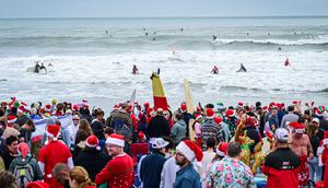 Pengunjung memadati acara Surfing Santa yang berlangsung di Pantai Cocoa, Florida, Amerika Serikat, Selasa (24/12/2024) waktu setempat. (AFP/Giorgio Viera)