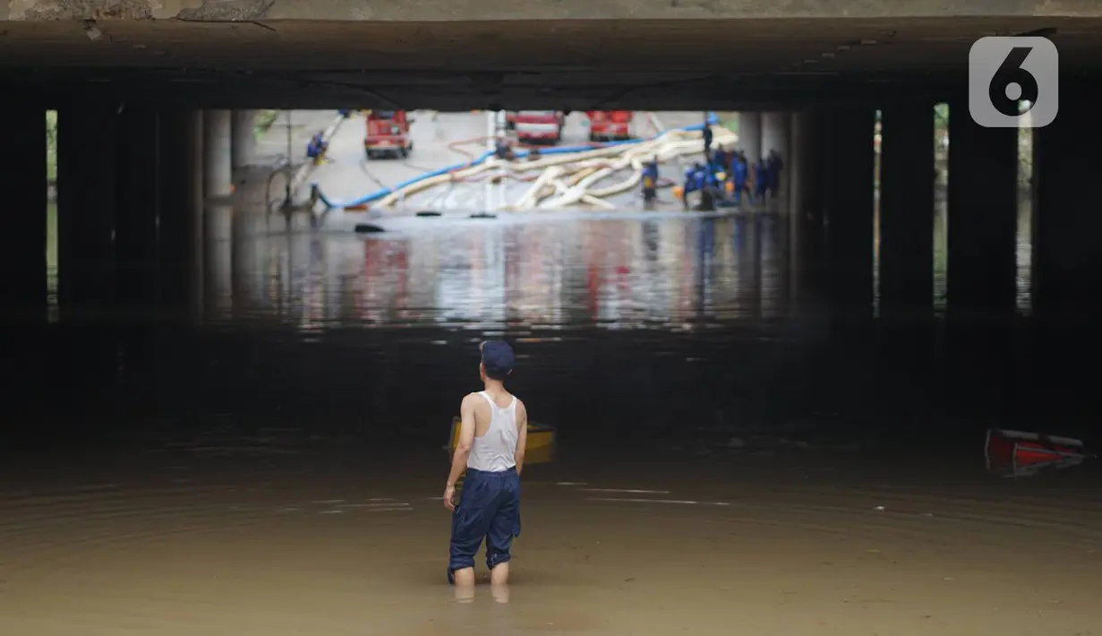 Petugas berdiri di antara banjir yang menggenangi underpass Kemayoran, Jakarta, Senin (3/2/2020). Curah hujan tinggi menyebabkan banjir yang menggenangi kawasan tersebut lama surut sehingga menutup arus lalu lintas. (Liputan6.com/Immanuel Antonius)
