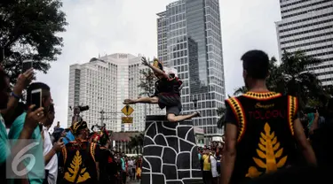 Atraksi seorang pria saat melakukan fahombo atau lompat batu dalam sebuah acara pagelaran seni dan kebudayaan Nias di Jalan Imam Bonjol, Jakarta, Minggu (12/2). Pagelaran ini diselenggarakan oleh Pemuda Peduli Nias. (Liputan6.com/Faizal Fanani)