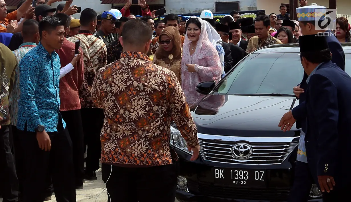 Putri Presiden Jokowi, Kahiyang Ayu turun dari mobil setibanya di lokasi upacara adat pemberian marga di rumah paman Bobby Nasution, di Medan, Selasa (21/11). Kahiyang tampil cantik mengenakan kebaya brokat berwarna pink. (Liputan6.com/Johan Tallo)