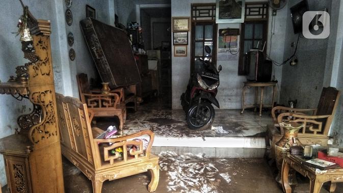 Lumpur sisa banjir mengotori rumah warga di Kebalen, Jakarta, Minggu (21/2/2021). Banjir yang terjadi kemarin karena curah hujan yang tinggi meninggalkan sampah di rumah warga. (Liputan6.com/Johan Tallo)
