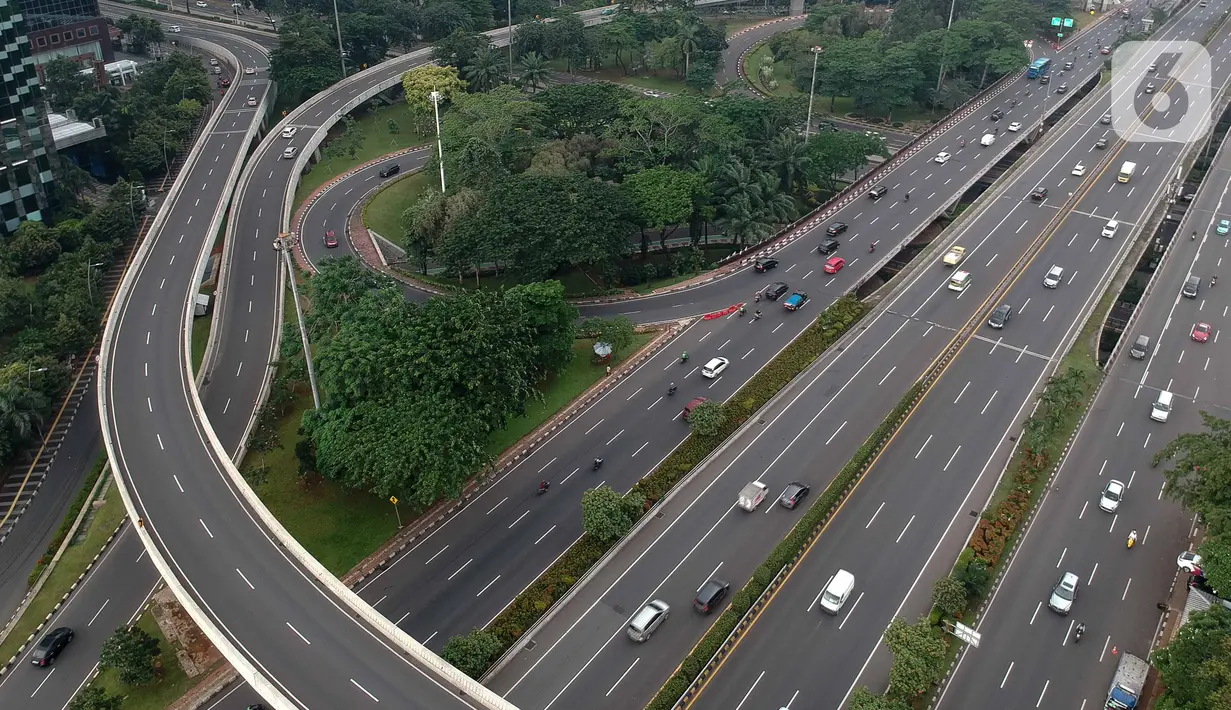 Foto aerial kendaraan melintas di Jalan Jenderal Sudirman, Jakarta, Selasa (24/3/2020). Sejumlah ruas jalan utama ibu kota lebih lengang dibandingkan hari biasa karena sebagian perusahaan telah menerapkan bekerja dari rumah guna menekan penyebaran COVID-19. (Liputan6.com/Faizal Fanani)